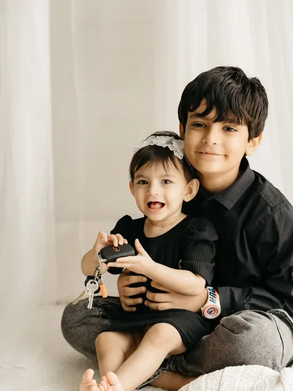 A classic portrait of a big brother holding his little sister. You can see the love and connection between them.