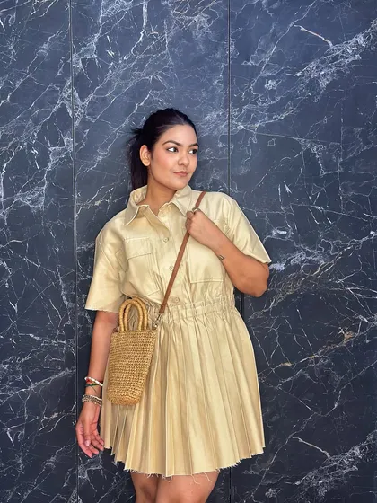 Here, I've added the detachable sling strap to the mini straw bag, showing its versatility as a cross-body purse for a hands-free, casual look.