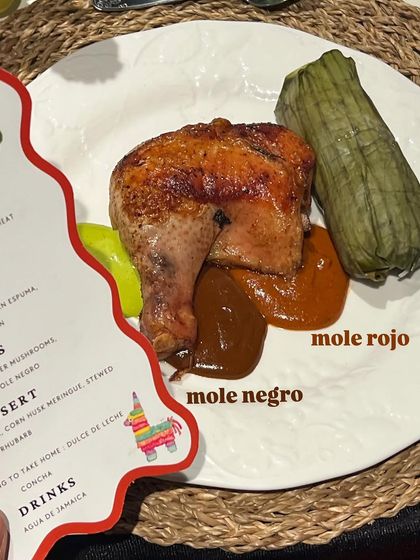 Roasted chicken served with two types of mole, rojo and negro, and a traditional tamale. A modern interpretation of classic Mexican flavors.