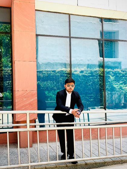 Leaning against a railing outside a court building. A warrior is most needed when the enemy is at the gate, and I am that warrior for my clients.