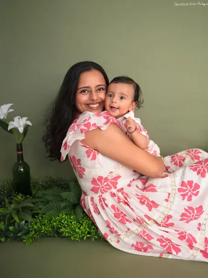 A sweet cuddle between a mother and her child. The soft green backdrop and floral outfits create a warm and natural feel for this portrait.