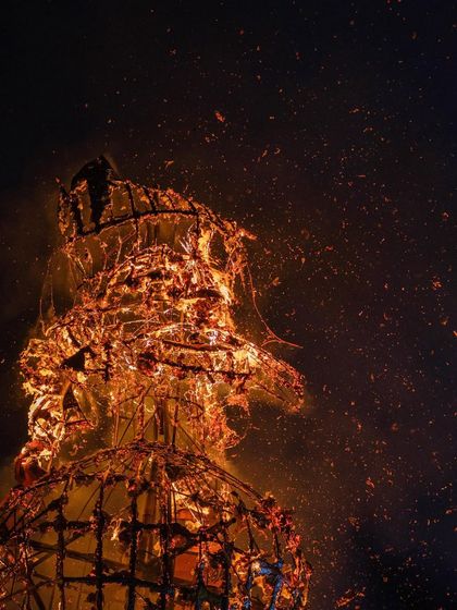 The skeletal structure of the effigy is visible as it burns, a powerful image of destruction and renewal.