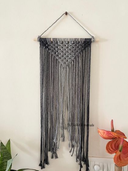 A single Ombré grey wall hanging. The way the color fades from dark grey to light grey is created by carefully arranging each cotton string. It's a simple design but very effective.