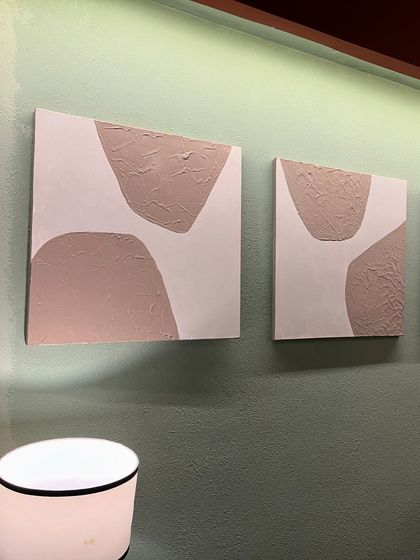 A set of three small 10" x 10" textured paintings installed at Sidewalk cafe in Lucknow. The simple, organic shapes in a neutral tone add a subtle artistic detail to the wall.