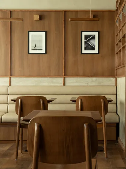 The clean, symmetrical lines of the banquette seating. The neutral upholstery and warm wood create a soothing and harmonious palette, characteristic of the Japandi aesthetic.