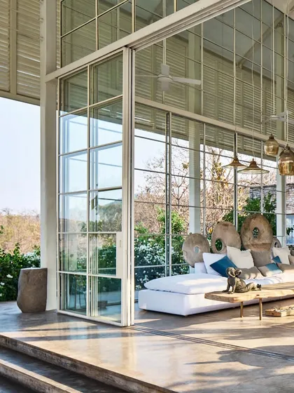 For The Ray Villa, we designed expansive, floor to ceiling glass walls that slide away completely, dissolving the boundary between the living area and the tropical landscape. This creates a seamless indoor outdoor living experience, allowing the home to breathe with its natural surroundings.