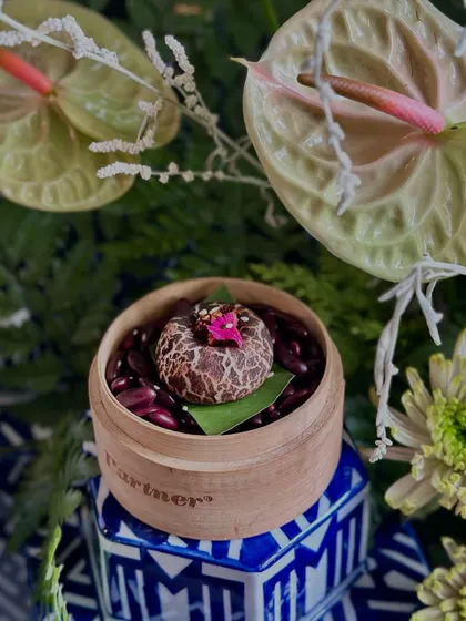 Our famous Truffle Shiitake Bao Bun, dusted with cocoa and presented on a bed of red beans in a bamboo steamer. An appetizer that always makes a statement.