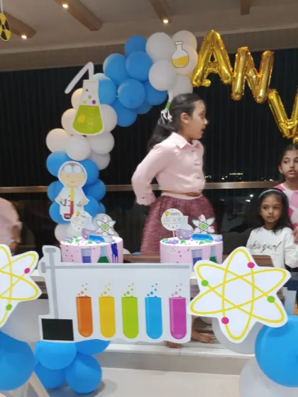 Kids gathering around the Science theme cake table, ready for the experiment of cake cutting.