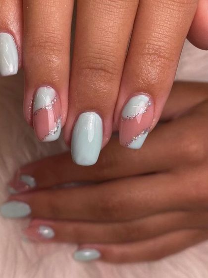 A cool-toned manicure with solid mint nails and accent nails featuring a silver glitter swirl. The negative space keeps the design feeling light and modern.