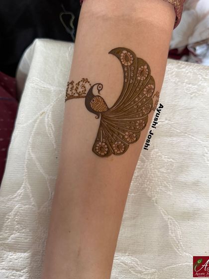 A detailed shot of the elegant peacock motif created for this engagement bride, showcasing the fine lines and floral details in its feathers.