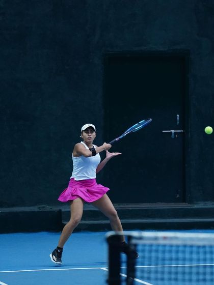 A player executes a forehand with perfect form during a practice match. The clean technique and focus are a direct result of our detailed technical coaching.