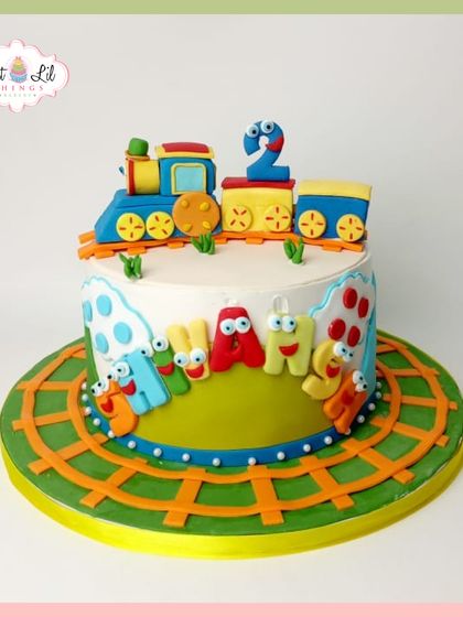 All aboard the birthday train! This colorful train-themed cake for a 2nd birthday features a cute engine and carriages, perfect for a little conductor.