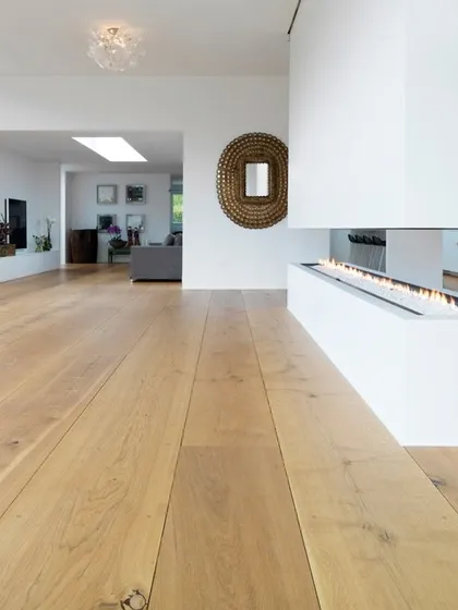 In this minimalist living area, I used a light-toned wood floor to create a calm and uncluttered atmosphere. The clean lines of the planks complement the modern fireplace and open-concept design. This is a perfect example of a sleek and easy-to-clean flooring option.