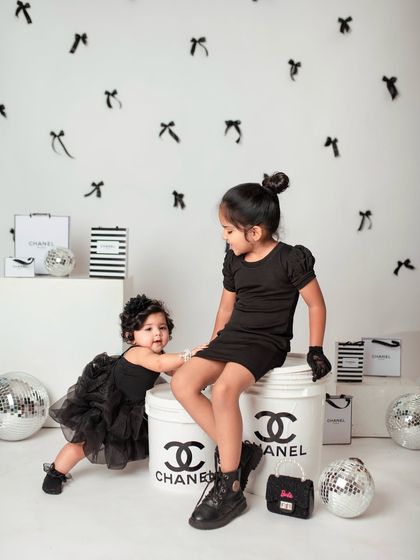 Showcasing a fun and creative themed shoot in the studio. These sisters are styled in black for a chic, high-fashion look with custom props.