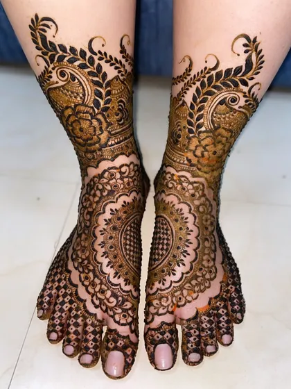 Your feet deserve beautiful mehendi too. Here is an intricate design with peacock and floral elements, creating a stunning pattern that covers the entire foot.