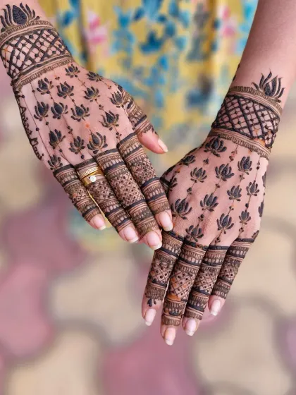A modern and elegant design featuring a pattern of bold lotus motifs. This Indo-Arabic style is perfect for clients who want a contemporary yet meaningful mehendi, with detailed work on the fingers.