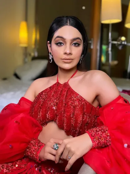 A confident portrait in the red gala outfit. The styling is bold and modern, perfect for a client who wants to make a statement.
