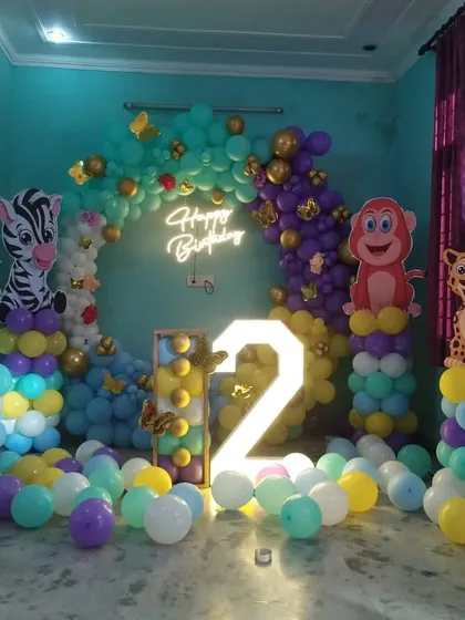 A wide shot of the jungle-themed second birthday party, showing the arrangement of balloon columns and animal cutouts.