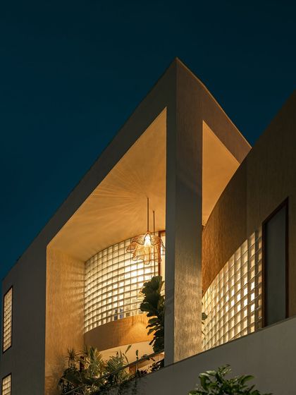 This series of images shows how the home's exterior transforms from day to night. The glass block walls, which provide privacy during the day, become luminous features in the evening, creating a warm and inviting aura.