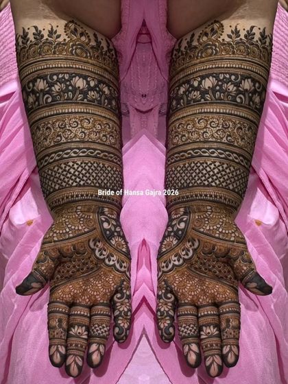 A classic band-style bridal mehendi. This design features structured layers of traditional patterns, including florals and jaali work, creating a look of perfect symmetry and rich detail.