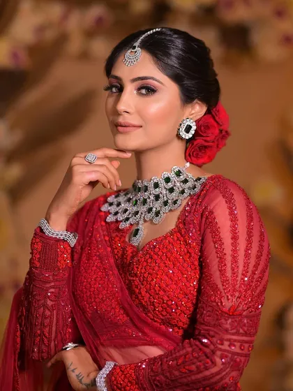 A portrait of a stunning bride in red. The makeup is glamorous and bold, perfectly suited for a bride who wants to make a statement on her wedding day.