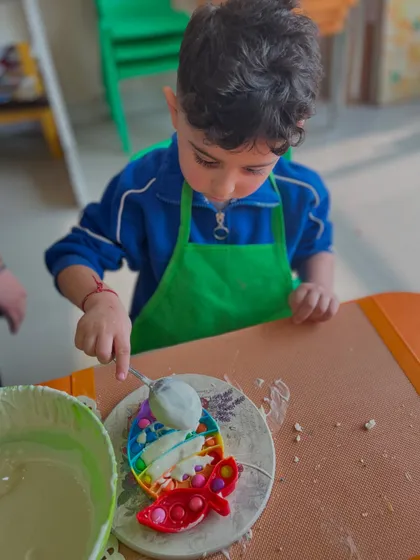 Another child enjoys the messy, fun process of making a chocolate pop-it.