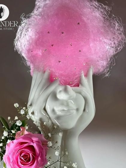 A cocktail that's pure fantasy. Served in an artistic ceramic glass, this drink is topped with a cloud of pink cotton candy for a whimsical touch.