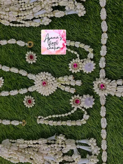 A simple and elegant baby shower set made from jasmine buds with pink stone accents. This set includes a necklace, earrings, maang tikka, and bajuband.