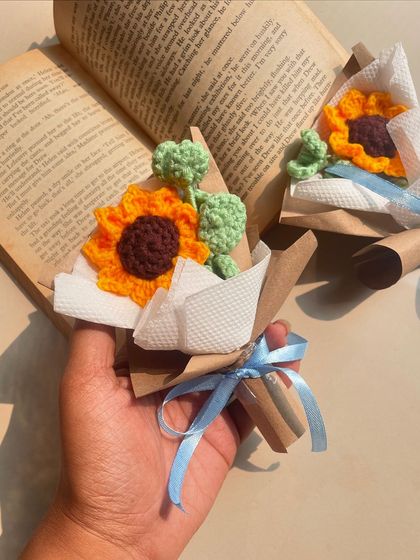 A mini sunflower bouquet, perfect for a book lover. This photo, styled with an open book, shows how these tiny arrangements can bring a little sunshine to your reading nook.