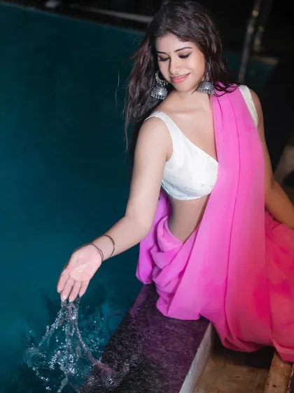 An interactive shot showing the model playfully splashing water. This adds a sense of story and personality to the fashion series, making it more engaging.