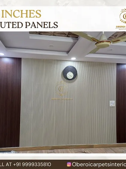 This living room wall features a combination of light-colored 12-inch fluted panels in the center, bordered by dark wood-finish panels. This two-tone design adds contrast and creates a defined space for a clock or artwork.