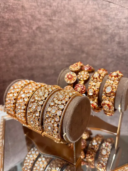 A display of our luxurious bangles, showcasing intricate kundan work and vibrant red enamel details.