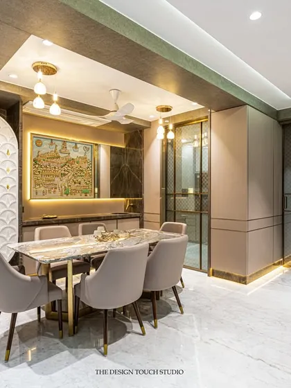This wide shot shows the entire dining and living area, highlighting the cohesive design language. The blend of textures, from the marble floor to the velvet chairs and wooden panels, creates a rich and inviting space.