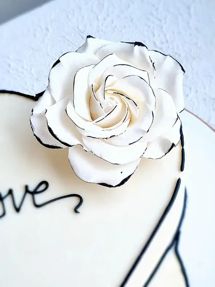 A close-up of the comic-style sugar rose, showing the delicate black-line detail.