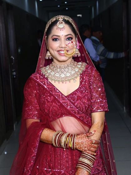 A happy bride smiling in our fully sequined magenta lehenga. This rental piece is perfect for the bride who wants to sparkle and shine throughout her wedding celebrations.