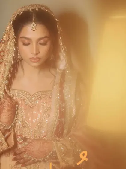 An artistic, dreamy shot of the bride in her magnificent peach and maroon bridal attire.