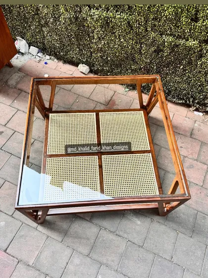 A top-down view of the glass and cane coffee table.