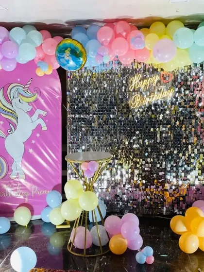 A slightly different angle of the unicorn and shimmer wall birthday decoration, showing the full spread of the pastel-colored balloons on the floor.