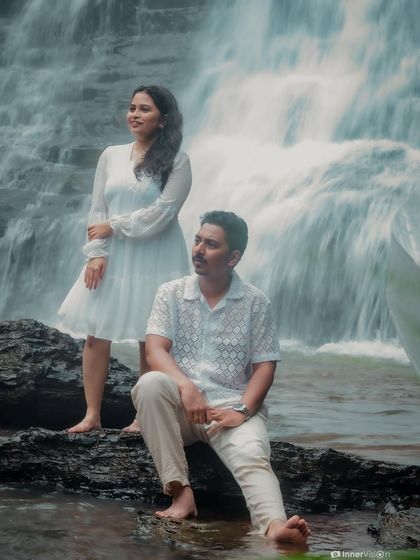 A creative and artistic pose in front of a beautiful waterfall. The couple stands apart but connected, creating a stylish and modern portrait against a powerful natural backdrop.