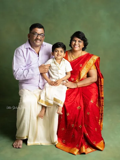A sweet portrait of a grandson with his grandparents. Dressed in traditional Indian clothing, their smiles radiate warmth and family pride.