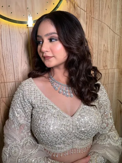 The soft waves in her hair perfectly complement the elegant makeup look.