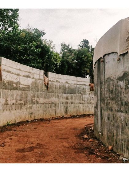 The curved retaining walls for the memorabilia gallery, creating a path through the raw earth of the site.