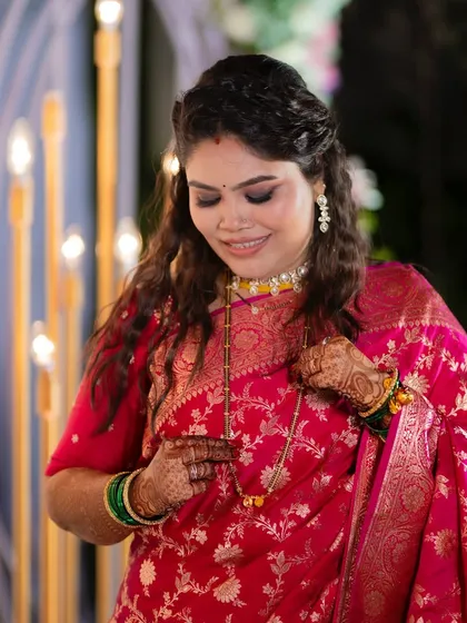 A close-up of the bride adjusting her mangalsutra. The soft smokey eye adds a touch of drama to her elegant reception look.