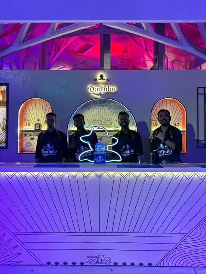 Our professional team posing behind the stylish, custom-built Don Julio bar. Their sharp uniforms and confident presence ensure that the service is as high-quality as the setup.