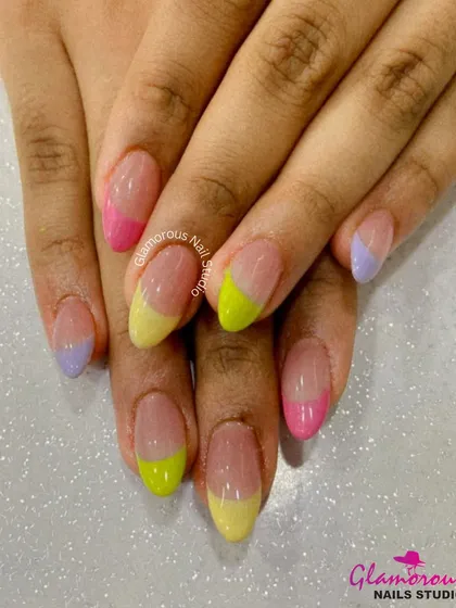 A playful pastel French manicure with a twist. Each nail features a different colored tip in yellow, pink, or lilac, applied at a fun angle.
