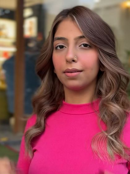 The client's new blonde-highlighted hair looks stunning in this outdoor shot. The natural light picks up the different tones, showcasing the dimension of the color.