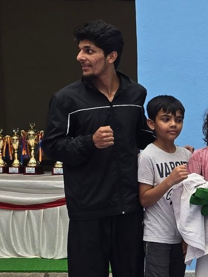 Standing with young medal winners in front of the trophy table. Their success is my greatest reward.