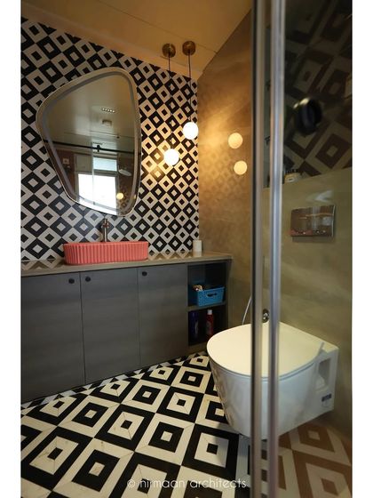 This bathroom in our 'Atmosphere' project makes a bold statement with black and white geometric tiles. The pop of color from the coral-pink basin adds a playful and unexpected touch.
