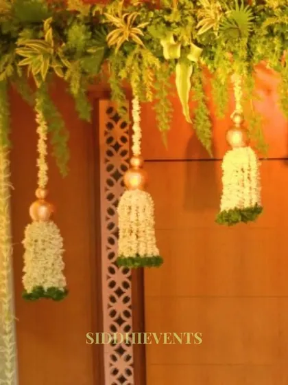 A close-up of traditional floral tassels made of white flowers, used as an elegant and fragrant decorative element for an entrance.