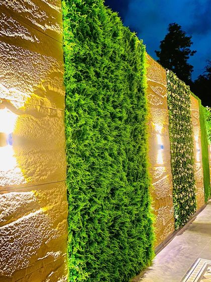 A closer look at the varied textures on the compound wall. We used different types of artificial greenery in separate panels to create a custom, dynamic design that looks beautiful day or night.